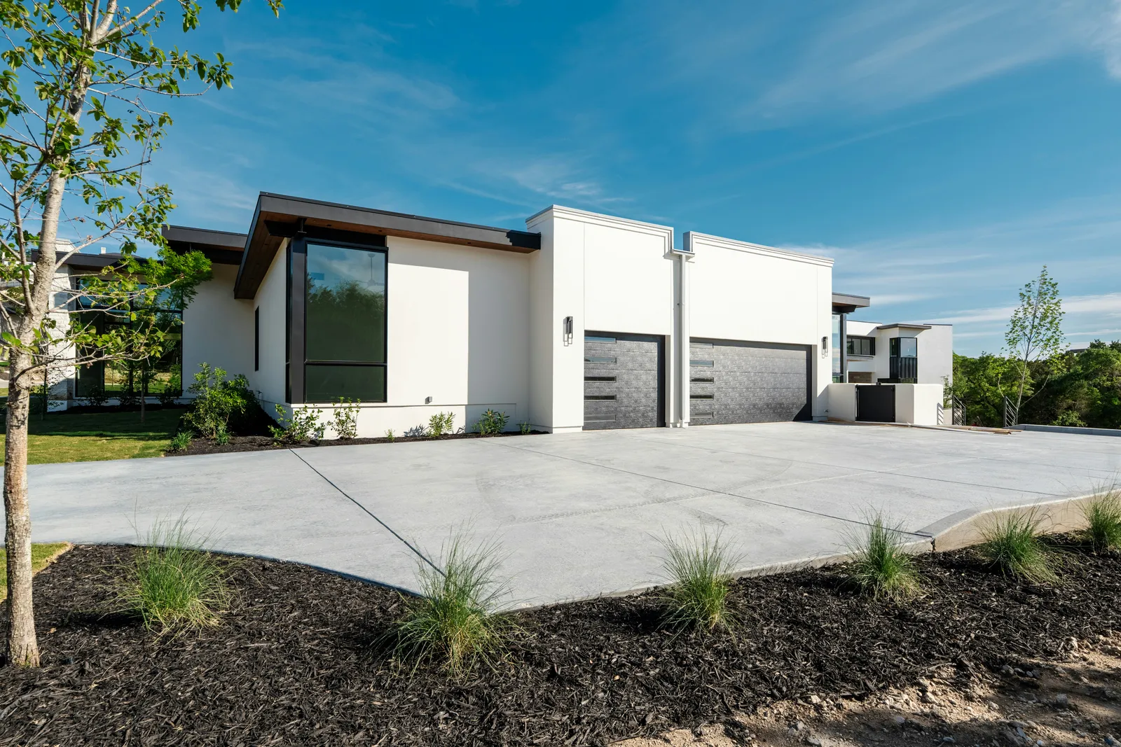 Freshly poured concrete driveway in front of a modern home