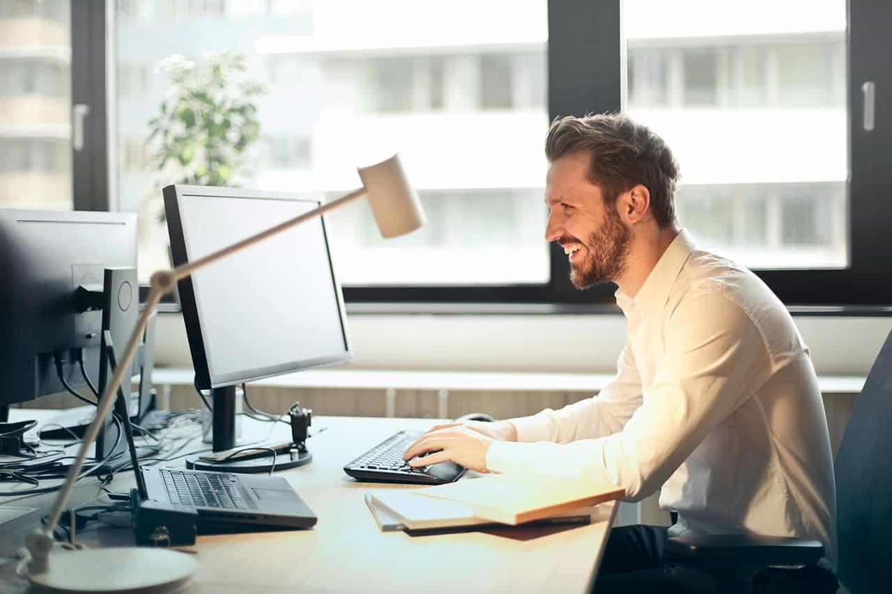A business owner working at a desk in a sunlit office